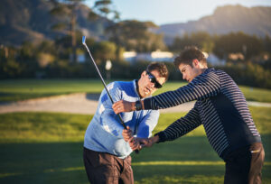 Young golf pro coaching a man on his golf swing, golf instruction Morton IL, golf coaching Morton IL, golf lessons near Morton IL, golf swing lessons Morton IL, private golf lessons Morton IL, beginner golf lessons Morton IL, golf training Morton IL, golf instructor Morton IL, indoor golf lessons Morton IL, golf simulator lessons Morton IL, golf coach near Morton IL, putting lessons Morton IL, golf improvement Morton IL, custom club fitting Morton IL, golf practice Morton IL, junior golf lessons Morton IL, adult golf lessons Morton IL, golf academy Central Illinois, golf lesson studio Morton IL, golf swing coach Morton IL